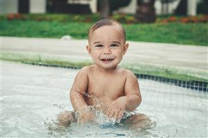 Toddler Boy Smiling In The Baby Pool